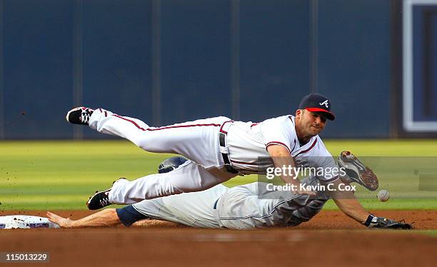 Chase Headley of the San Diego Padres steals second base under Dan Uggla of the Atlanta Braves in the first inning at Turner Field on June 1, 2011 in...