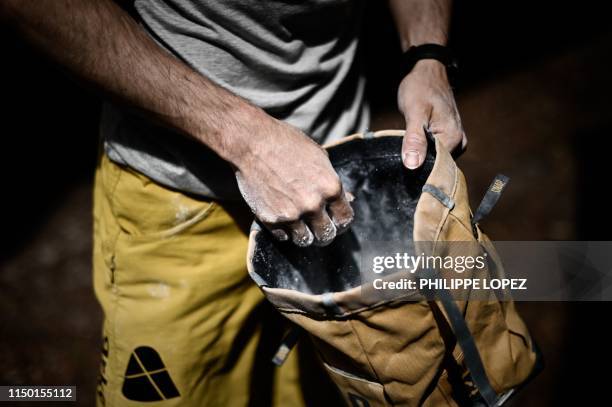 French climber Jeremy Bonder uses climbing chalk during a demonstration of his skills at bouldering -a form of rock climbing that is performed on...