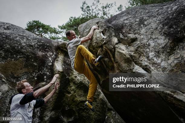 French climber Jeremy Bonder is assisted by fellow climber Jacky Godoff , as he demonstrates his skills at bouldering -a form of rock climbing that...