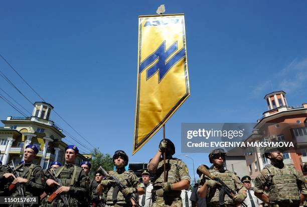 Servicemen of the "Azov" regiment and Ukrainian National Guard march through the city of Mariupol as they take part in a parade to mark the 5th...