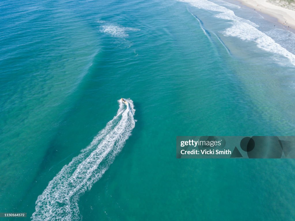 Oceans waters as seen from above with a jet ski racing along