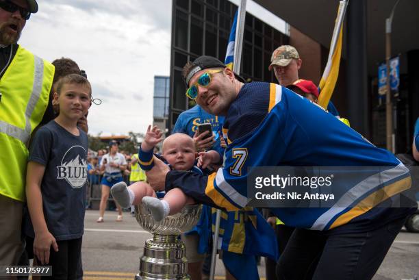 Pat Maroon of the St. Louis Blues places a baby in the Stanley Cup during the St Louis Blues Victory Parade and Rally after winning the 2019 Stanley...