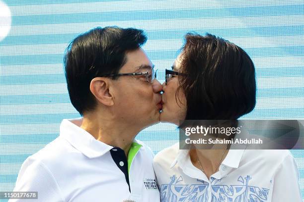 Singapore Deputy Prime Minister and Minister of Finance, Heng Swee Keat kisses his wife, Chang Hwee Nee during the launch of Celebrating Fathers' -...