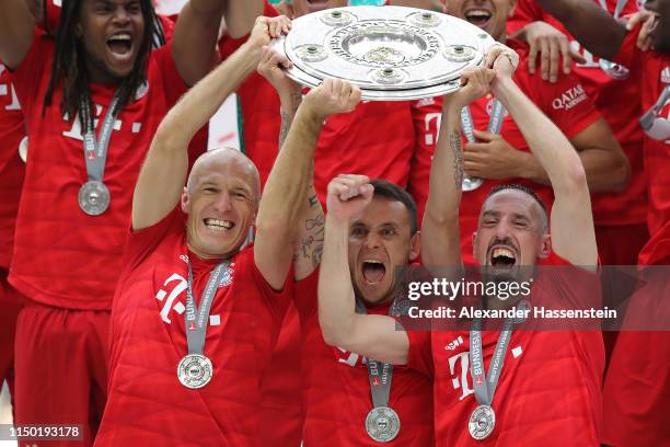 Arjen Robben, Franck Ribery and Rafinha of Bayern Munich lift the trophy following the Bundesliga match between FC Bayern Muenchen and Eintracht...