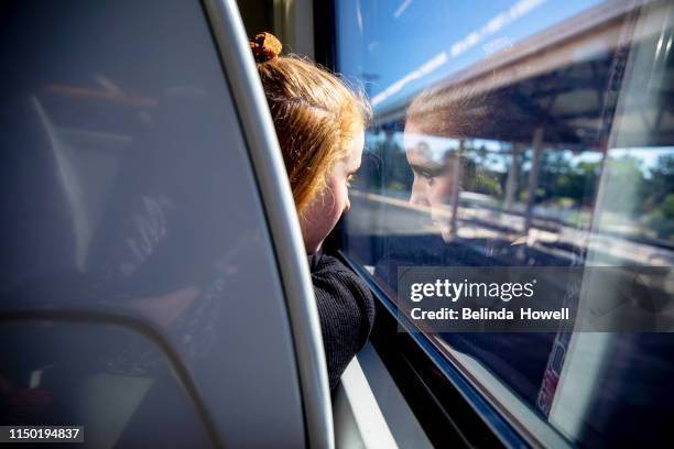 teen girl with red hair tavels on the train listening to music and looking at her mobile phone - emo girl stock pictures, royalty-free photos & images