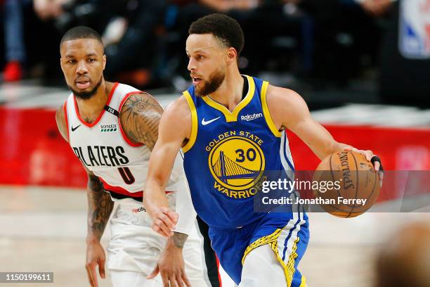 Stephen Curry of the Golden State Warriors dribbles against Damian Lillard of the Portland Trail Blazers during the second half in game three of the...