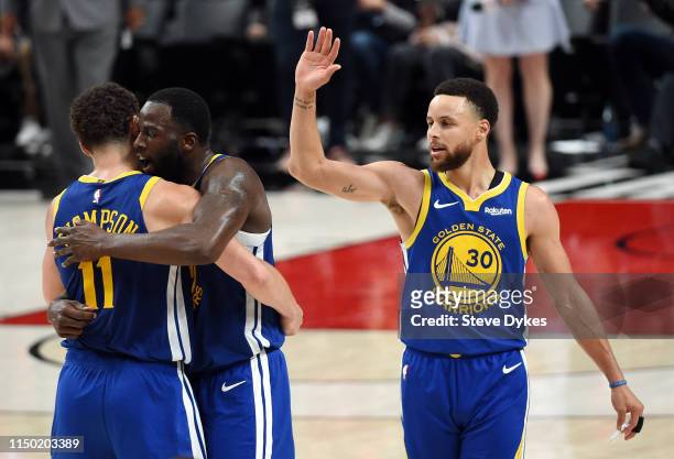 Stephen Curry of the Golden State Warriors high fives teammates during the second half against the Portland Trail Blazers in game three of the NBA...