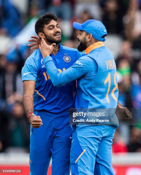 Virat Kohli of India congratulates Vijay Shankar on taking the wicket of Imam-ul-Haq during the Group Stage match of the ICC Cricket World Cup 2019...