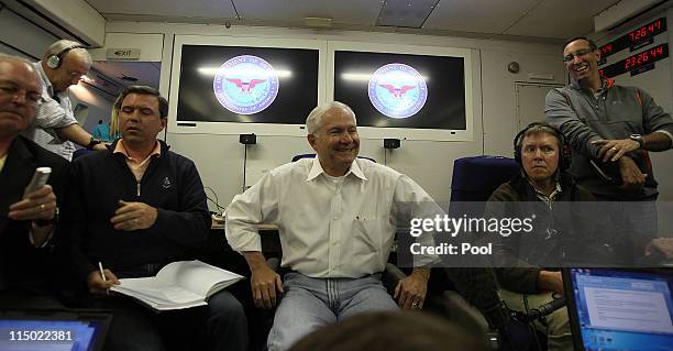 Secretary of Defense Robert Gates smiles as he speaks to the press aboard his aircraft on June 2, 2011 over the Pacific Ocean between Hawaii and...