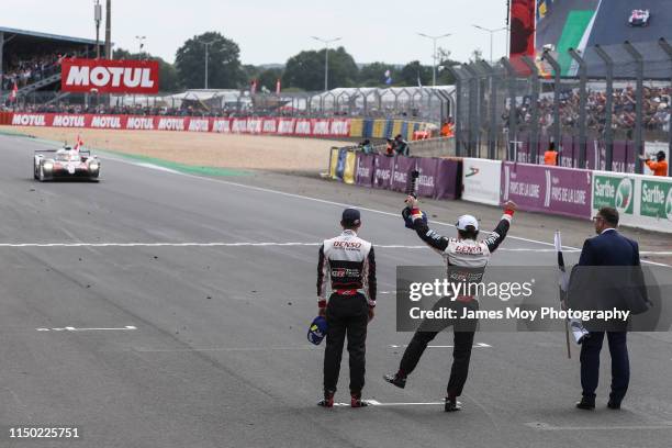 Sebastien Buemi of Switzerland and Toyota Gazoo Racing and Fernando Alonso of Spain and Toyota Gazoo Racing celebrate as Kazuki Nakajima of Japan and...