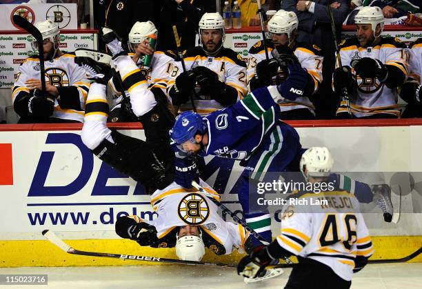 Milan Lucic of the Boston Bruins gets flipped after being check by Dan Hamhuis of the Vancouver Canucks during game one of the 2011 NHL Stanley Cup...