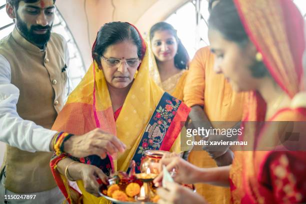 priest assisting family in preparing puja thali - show respect stock pictures, royalty-free photos & images