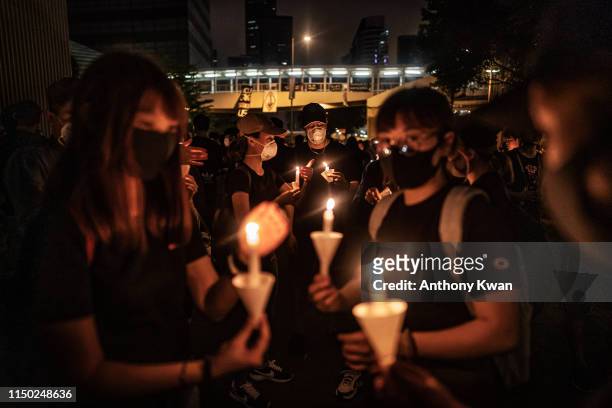 Mourners hold candles during a candlelight vigil to commemorate a protestor who died last night during a rally against a controversial extradition...