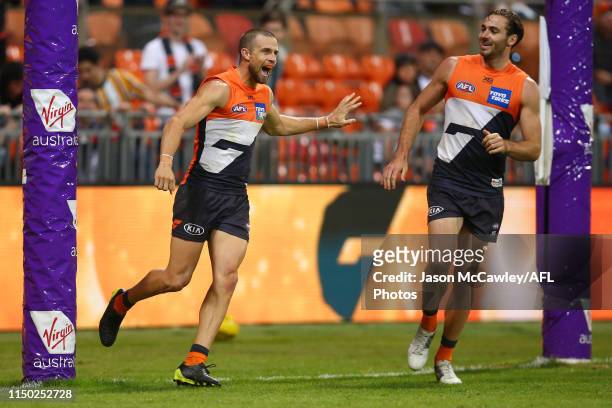 Brett Deledio and Jeremy Finlayson of the Giants celebrate a goal during the round nine AFL match between the Greater Western Sydney Giants and the...
