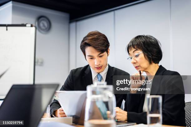 asian colleagues analyzing business data - hong kong men and women office stock pictures, royalty-free photos & images