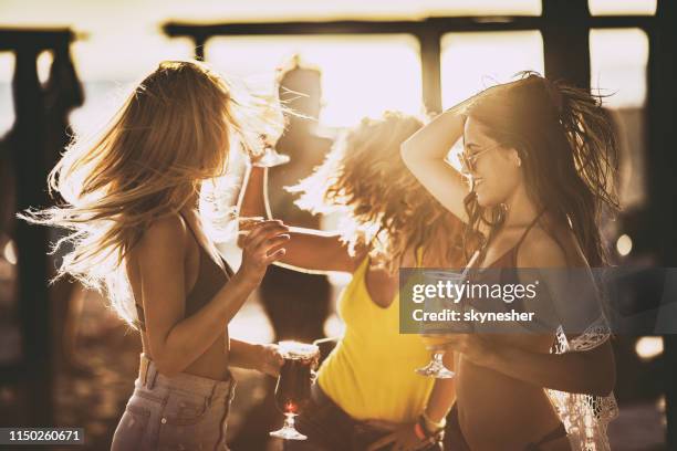 young beautiful women dancing on the beach party at sunset. - beach cocktail party stock pictures, royalty-free photos & images