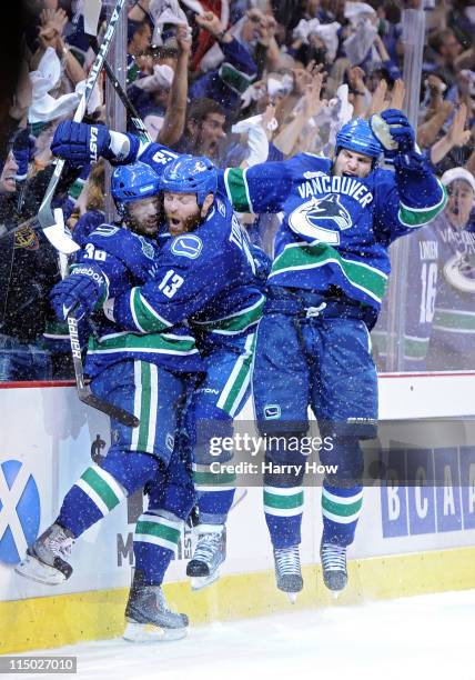 Raffi Torres of the Vancouver Canucks celebrates with his teammates Victor Oreskovich and Kevin Bieksa after a goal late in the third period against...