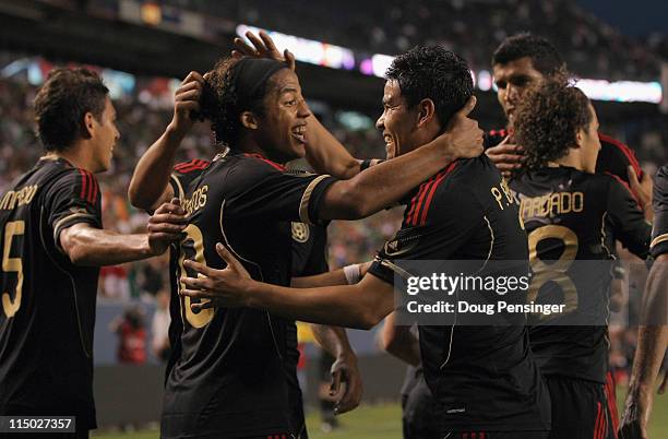 Giovani Dos Santos of Mexico celebrates his second goal of the game with Pablo Barrera in the 30th minute against New Zealand at INVESCO Field at...