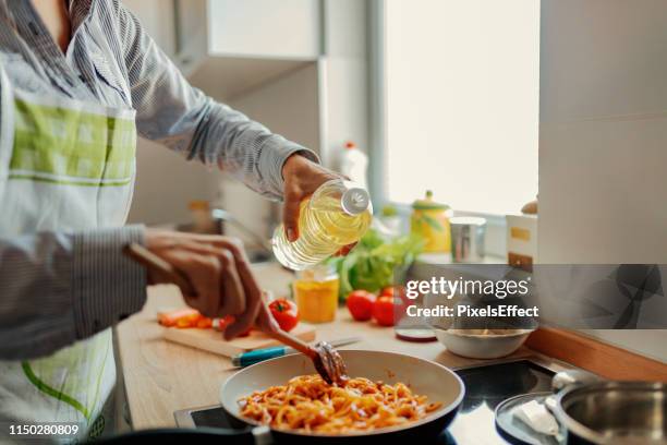 woman adding olive from bottle - stir frying european stock pictures, royalty-free photos & images