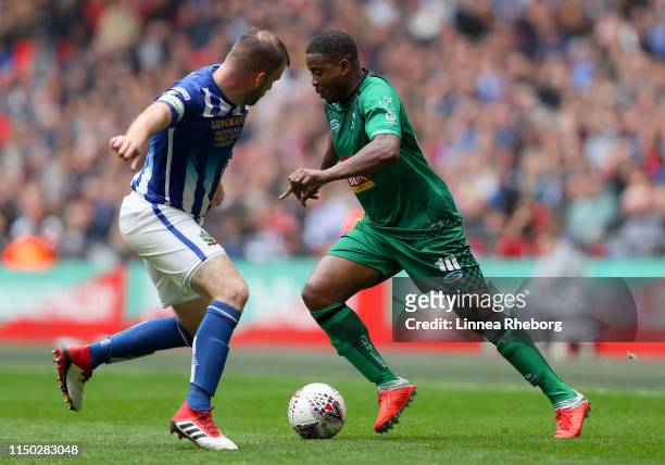 Kevin Lisbie of Cray Valley competes for the ball with Michael Peacock of Chertsey Town during the Buildbase FA Vase Final match between Chertsey...