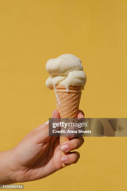 ice cream cones against a yellow wall - vanilla ice cream stock pictures, royalty-free photos & images