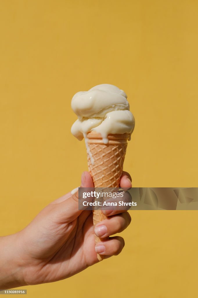 Ice cream cones against a yellow wall
