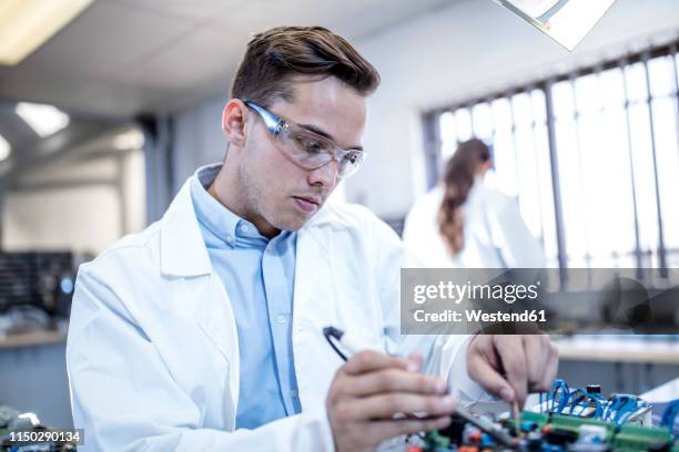 technician working on motherboard - motherboard stock-fotos und bilder