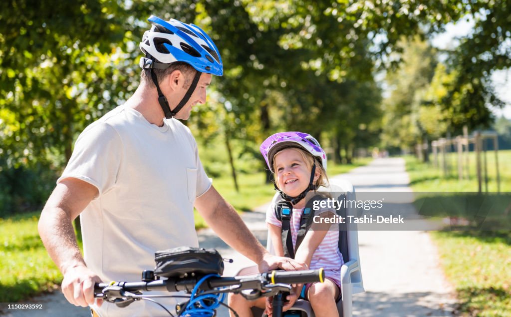 Vater und Kind auf Fahrrädern im Park