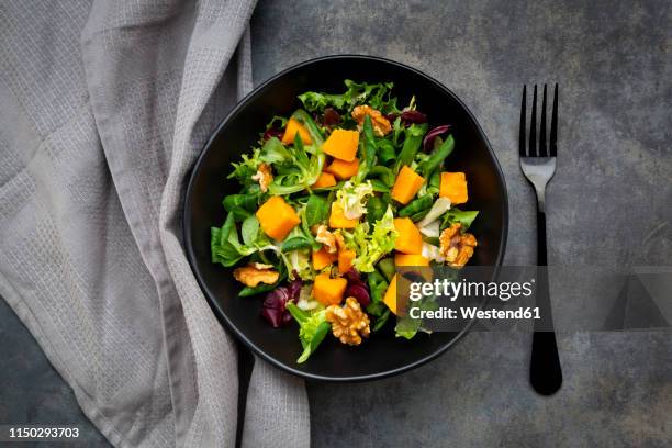 bowl of mixed green salad with hokkaido pumpkin and walnuts - radicchio stockfoto's en -beelden