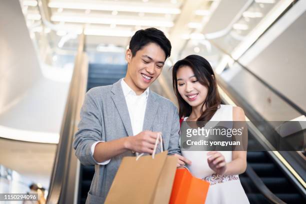 young couple shopping in a mall - couple shopping in shopping mall stock pictures, royalty-free photos & images