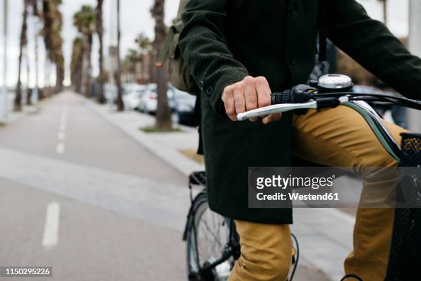 close-up of man riding e-bike on a promenade - handlebar stock pictures, royalty-free photos & images