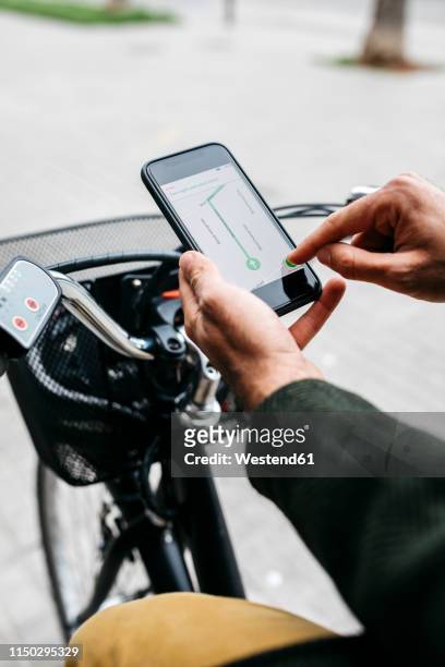 close-up of man with e-bikeusing smartphone navigation system - satnav photos et images de collection