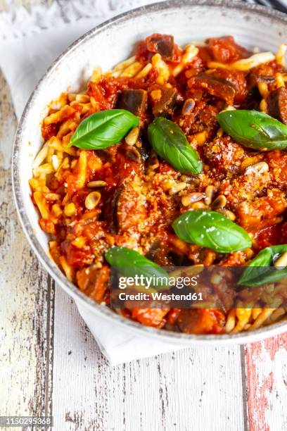 bowl of pasta with aubergine tomato sugo garnished with pine nuts, parmesan and basil - sugo pomodoro stock-fotos und bilder