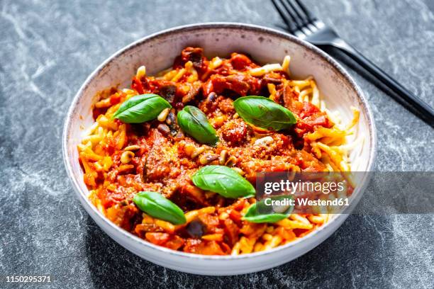 bowl of pasta with aubergine tomato sugo garnished with pine nuts, parmesan and basil - sugo pomodoro stock pictures, royalty-free photos & images