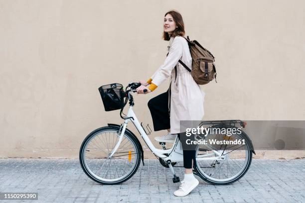 woman with e-bike at a wall - woman on bicycle stock pictures, royalty-free photos & images