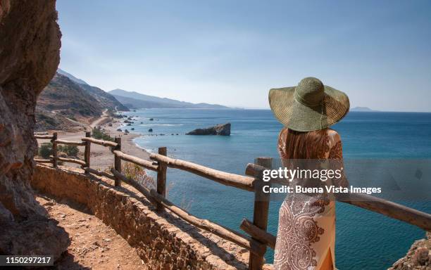 young woman watching  mediterranean coastline. - crete scenics stock pictures, royalty-free photos & images