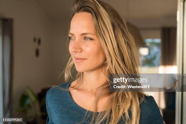 portrait of blond woman at home looking sideways - pensive man stock-fotos und bilder