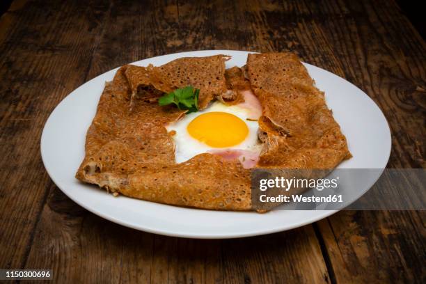 galette complete, breton buckwheat pancake with egg, cheese und ham, glutenfree - buckwheat fotografías e imágenes de stock