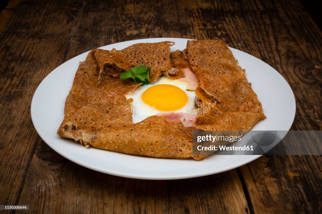 Galette complete, Breton buckwheat pancake with egg, cheese und ham, glutenfree