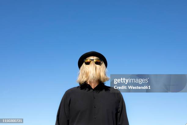 blond hair covering man's face wearing sunglasses and bowler hat - bowler hat stock pictures, royalty-free photos & images