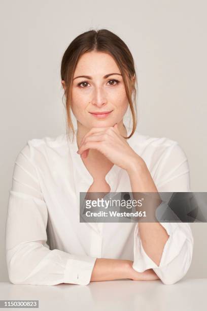 portrait of smiling young woman wearing white blouse - hand am kinn stock-fotos und bilder
