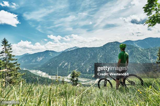 germany, bavaria, isar valley, karwendel mountains, mountainbiker on a trip having a break on alpine meadow - karwendel mountains 個照片及圖片檔