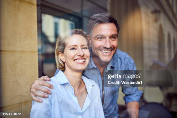 portrait of happy couple behind windowpane - business mature couple portrait bildbanksfoton och bilder