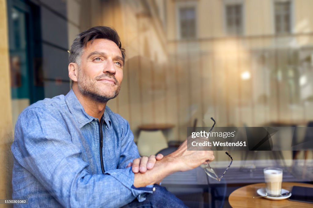 Portrait of man behind windowpane in a cafe
