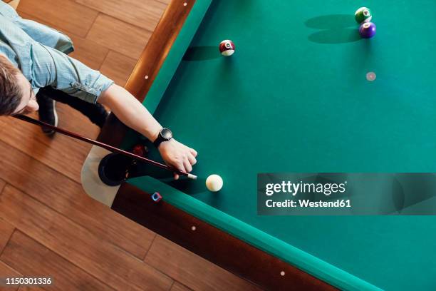 top view of man playing billiards - billard tisch stock-fotos und bilder