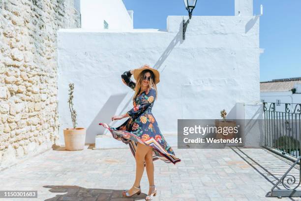 spain, cadiz, vejer de la frontera, portrait of fashionable woman moving on roof terrace - andalucía de moda stock-fotos und bilder