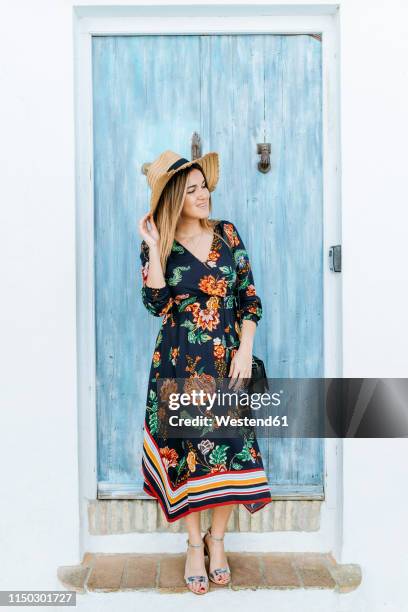 spain, cadiz, vejer de la frontera, fashionable woman standing in front of light blue wooden door - andalucía de moda stock-fotos und bilder