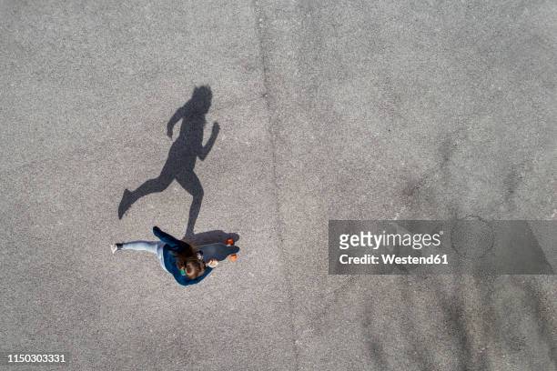 woman longboarding, top view - asphalt von oben stock-fotos und bilder
