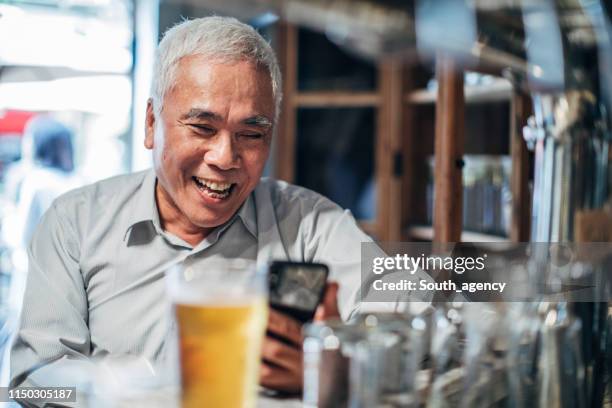 senior man in the pub - senior men beer stock pictures, royalty-free photos & images