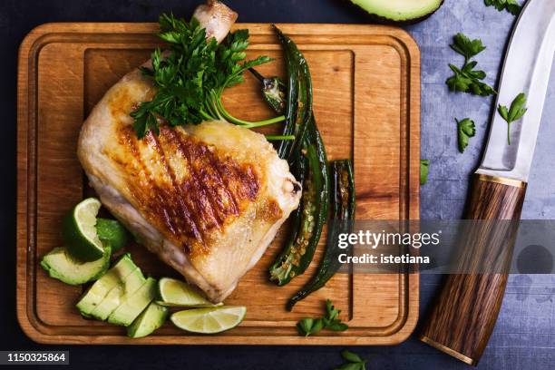 grilled chicken leg and green vegetables on cutting board - bbq avocado imagens e fotografias de stock